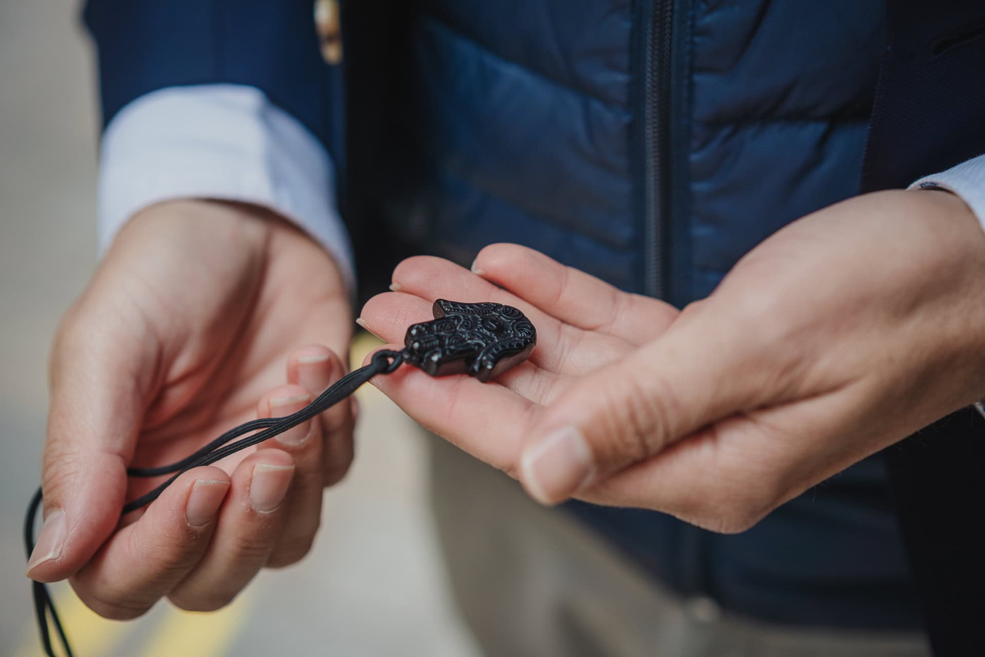 Zach Reynolds holds a black Hamsa hand pendant, a symbol of protection.