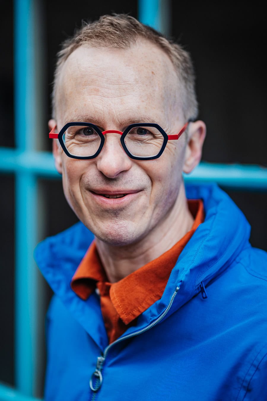 Richard Jones, a man with glasses, smiles warmly, embodying authentic presence. London brand photographer Phil Askew's work.
