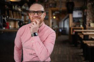 Ciaran Henderson, a London brand photographer, in a warm pub setting.