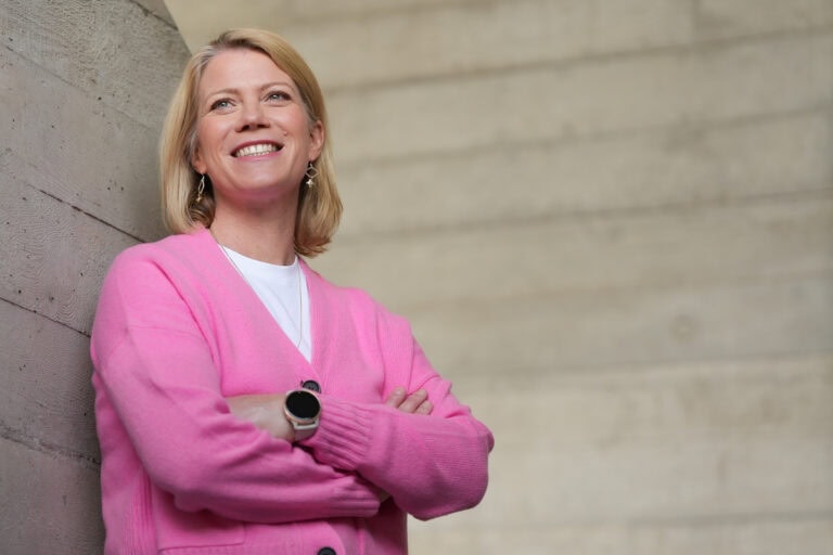 Meg Lyons, a confident leader, smiles warmly, photographed by London brand photographer Phil Askew.