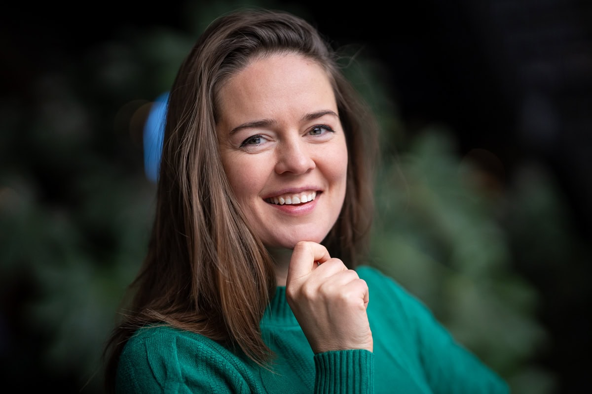 Katrin Mantay, a confident leader, smiles warmly in a natural portrait captured by a London brand photographer.