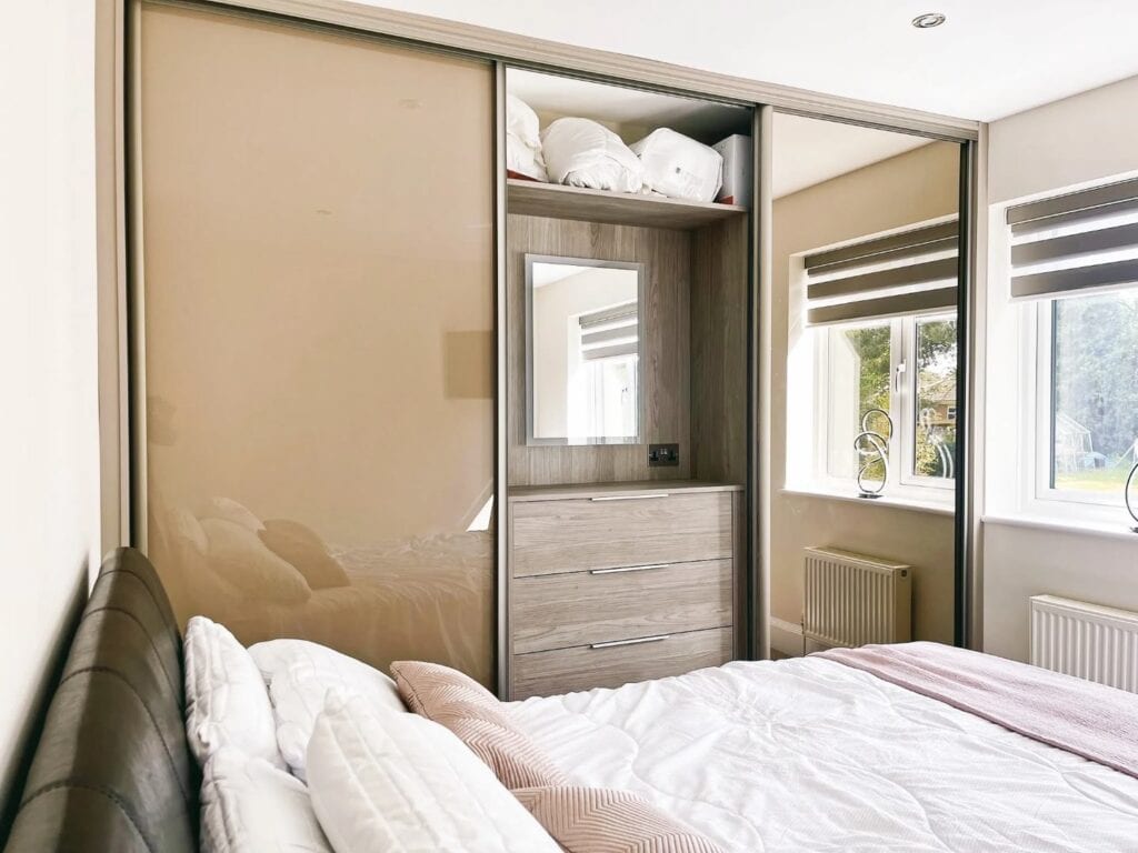 Built-in wardrobe with custom sliding doors and integrated mirror for modern bedroom storage.