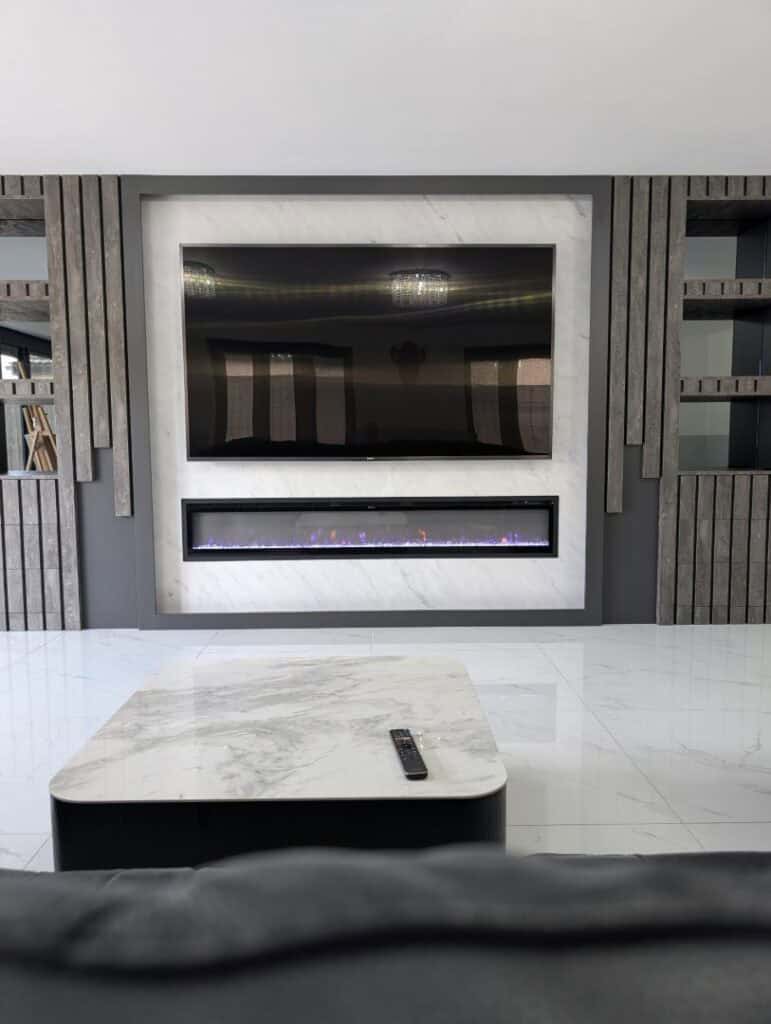 Modern custom-made living room fire feature with built-in electric fireplace and sleek TV unit.