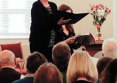 Enjoying a live performance by Macclesfield Oriana Choir, featuring choir members singing in a warm, inviting atmosphere.