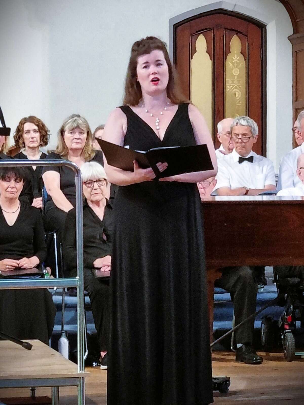 Elegant female choir singer performing at Oriana Choir Macclesfield concert, delivering a captivating vocal performance.