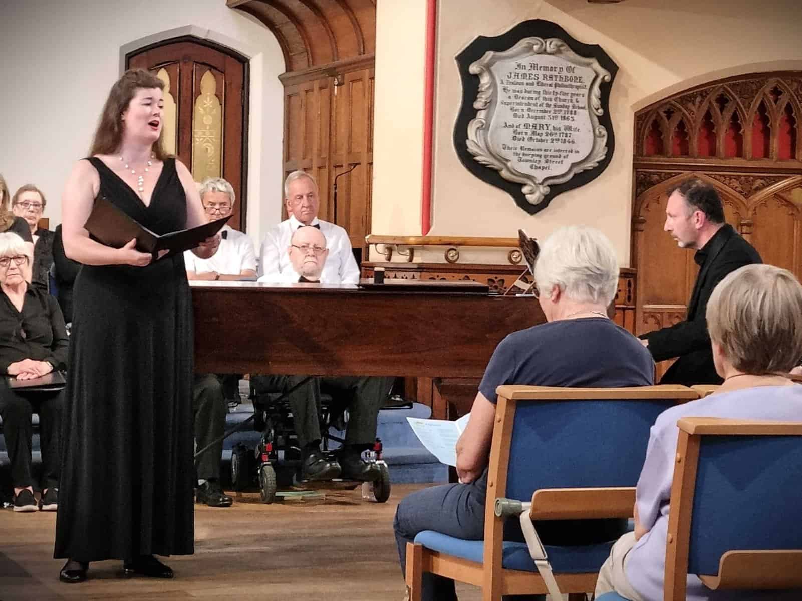 Elegant female choir singer performing at Oriana Choir Macclesfield concert, showcasing choral music in a historic church.