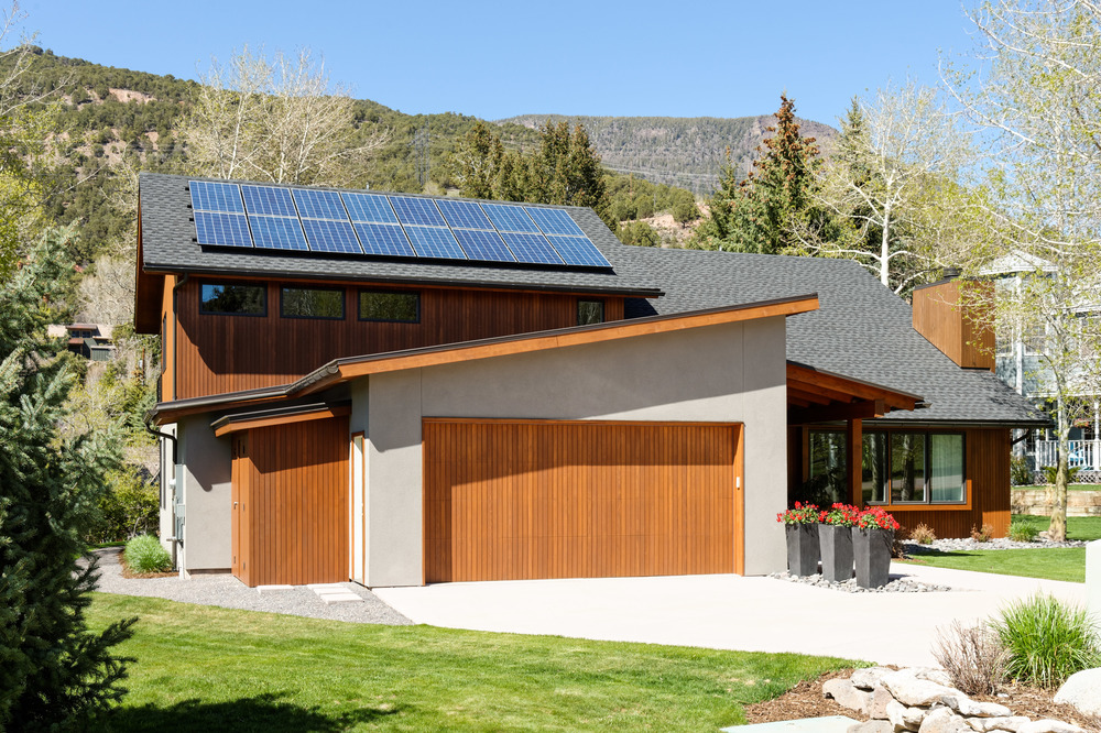The garage and entryway of a custom modern home and its solar panels