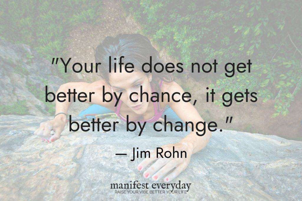 Young woman reaching the top of a rock wall she climbed in the jungle with quote text that reads "Your life does not get better by chance, it gets better by change." - Jim Rohn manifesteveryday.com