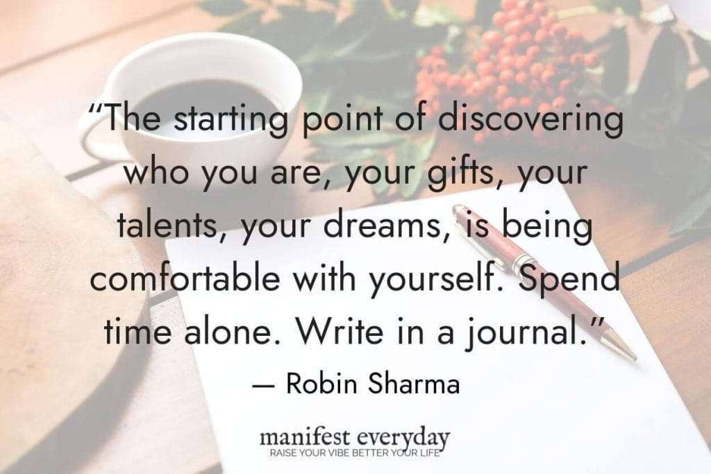 a cup of coffee on a desk with paper and pen with quote text that reads “The starting point of discovering who you are, your gifts, your talents, your dreams, is being comfortable with yourself. Spend time alone. Write in a journal.” — Robin Sharma manifesteveryday.com