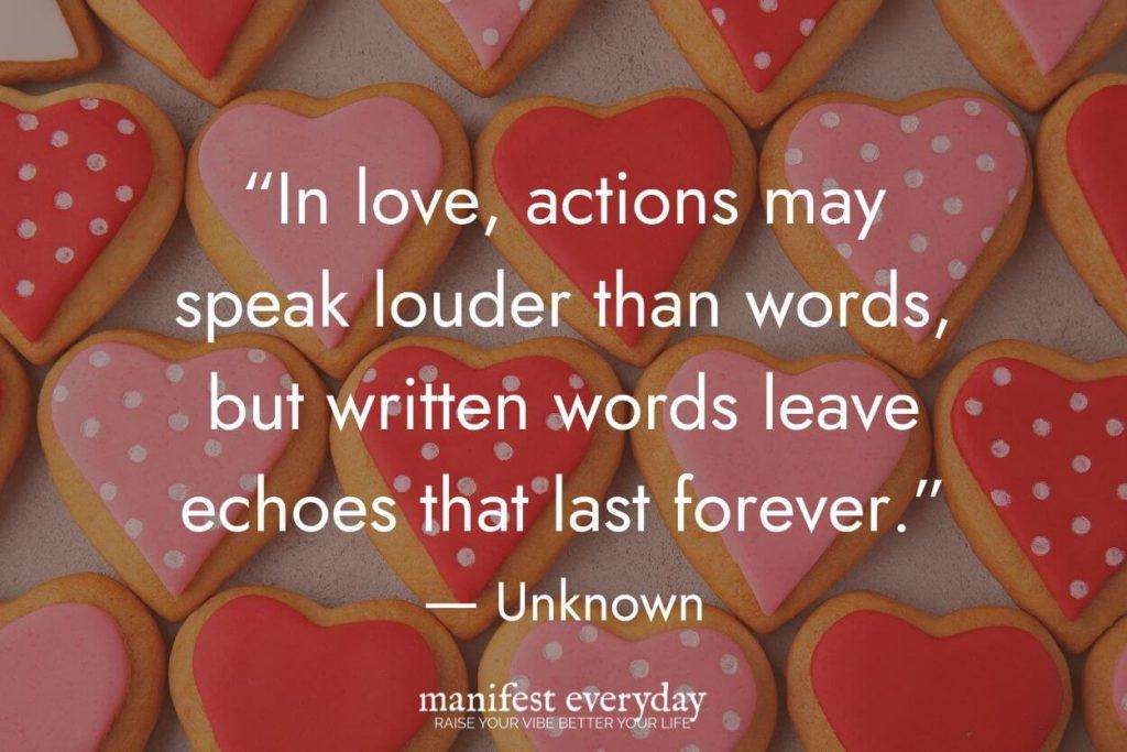 Valentine's Day quote overlaid on background of red and pink heart-shaped cookies with polka dot designs reading 'In love, actions may speak louder than words, but written words leave echoes that last forever. - Unknown' with manifesteveryday.com branding