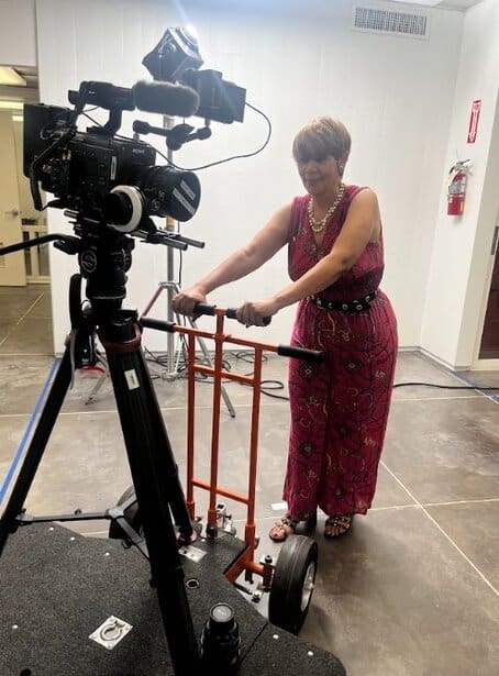 Experienced woman operating film equipment at UOhnIt.com event.