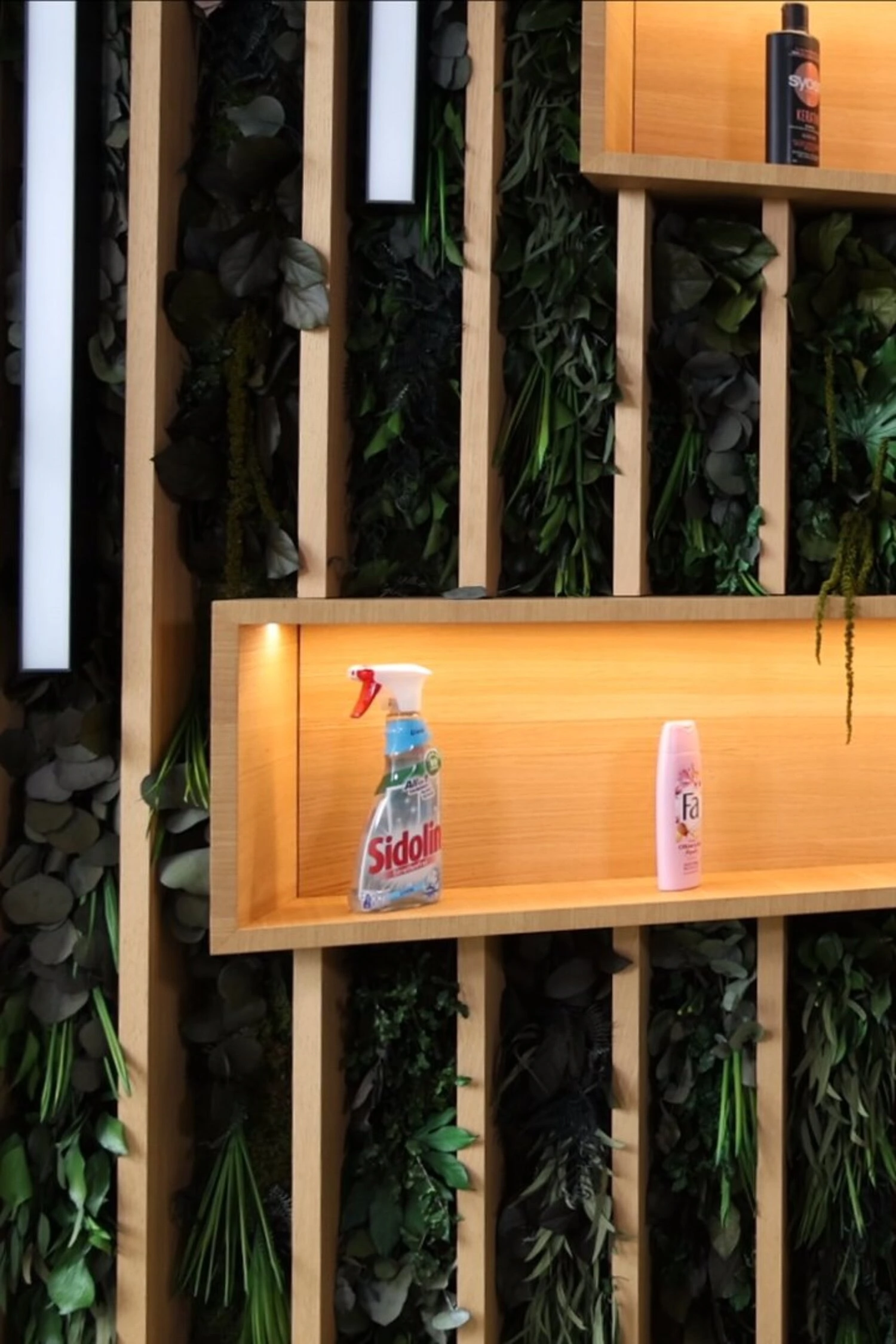 Hautnahes Bild einer Frau in einem modernen Laden mit Reinigungsprodukten an der Wand.