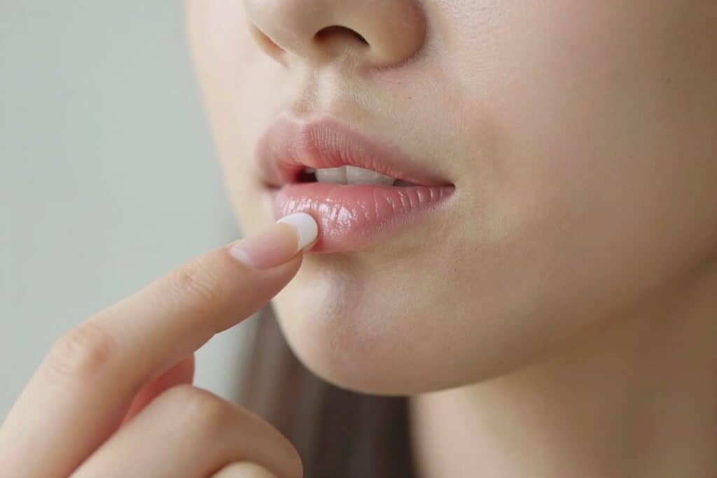 Person applying homemade castor oil lip balm