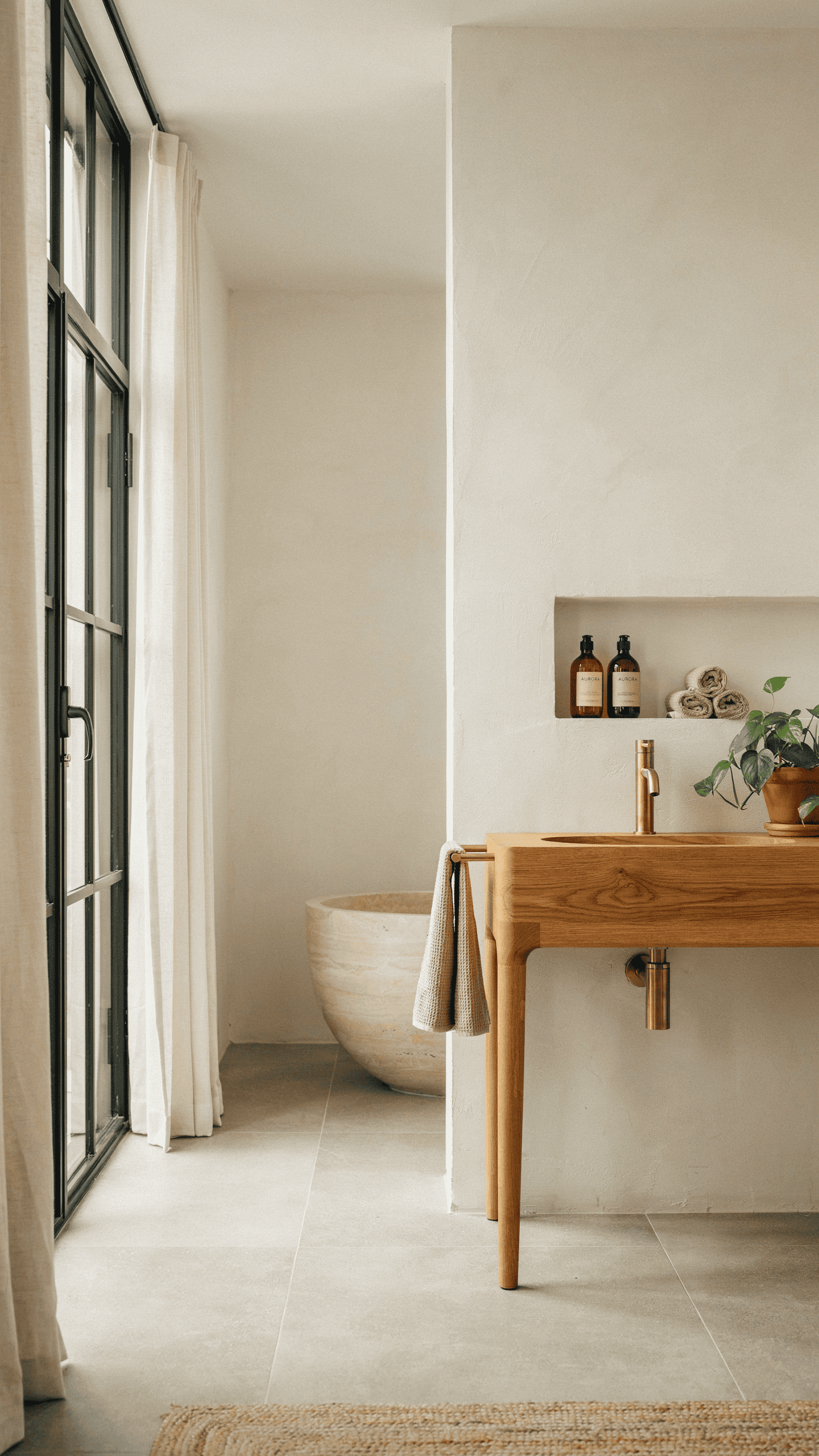 Scandinavian bathroom with warm white walls, natural oak vanity, soft lighting, and minimalist Nordic styling.