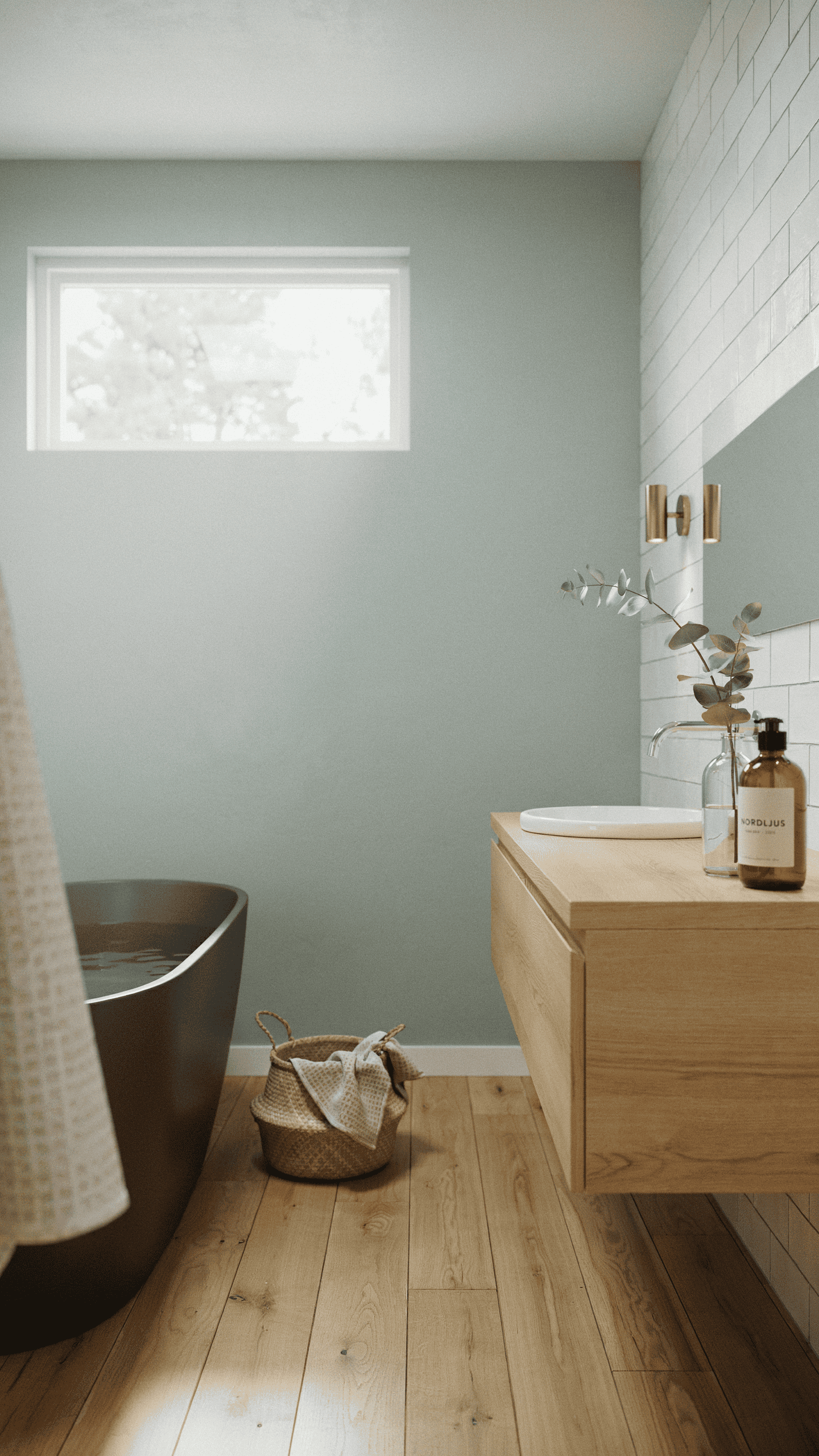 Scandinavian bathroom featuring pale sage green walls, light oak accents, white tiles, and spa inspired styling.