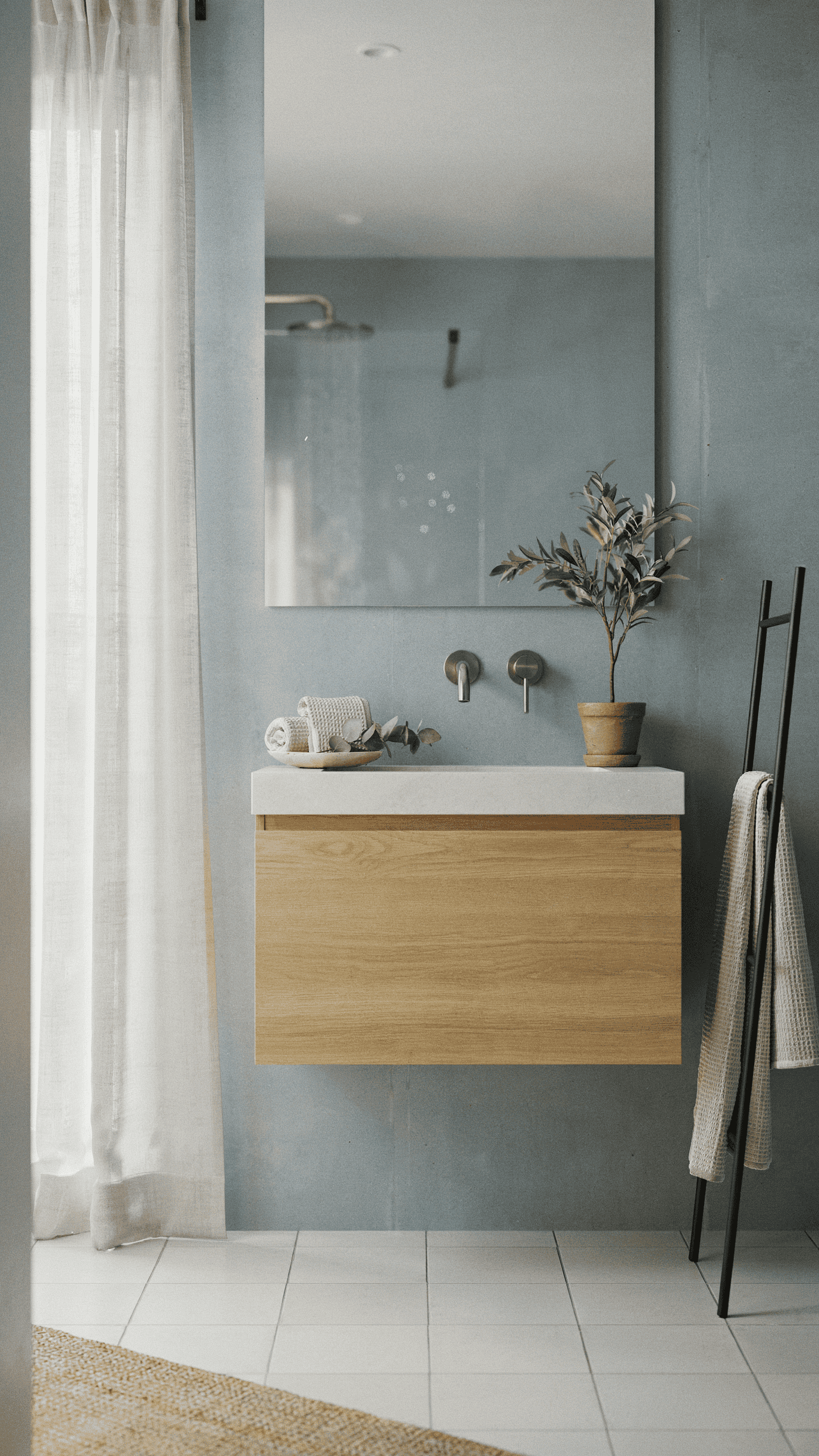 Scandinavian bathroom with misty blue gray walls, white tiles, light wood vanity, and calming spa inspired design.