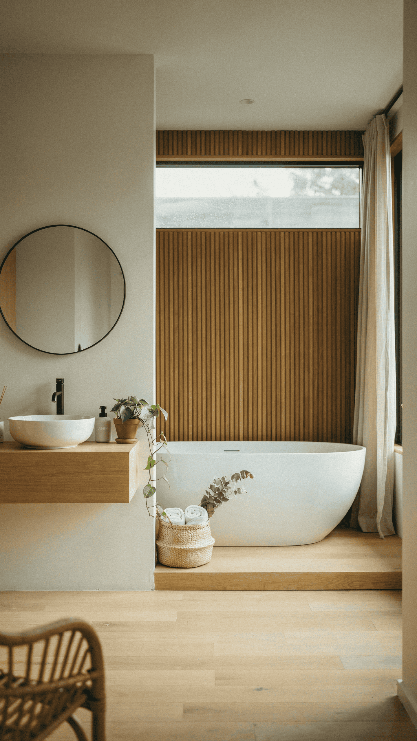 Layered neutral Scandinavian bathroom with warm whites, beige tones, oak textures, and soft natural lighting.
