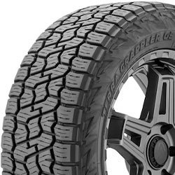 All-terrain tire with rugged tread pattern and black alloy wheel.