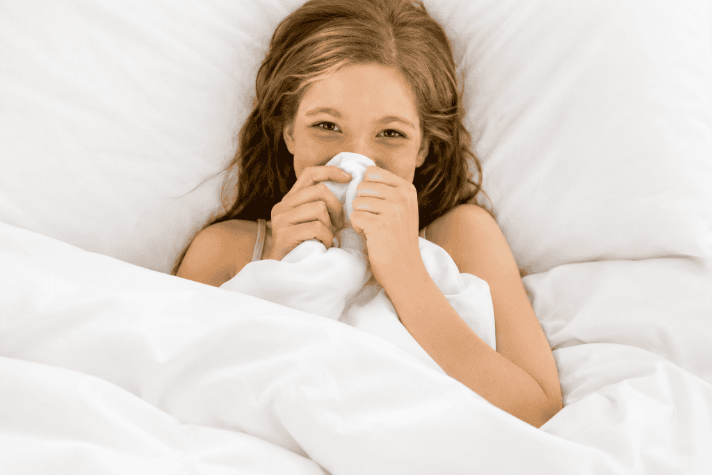 Young girl resting comfortably under a natural silk doona in a bright healthy bedroom with soft breathable bedding.