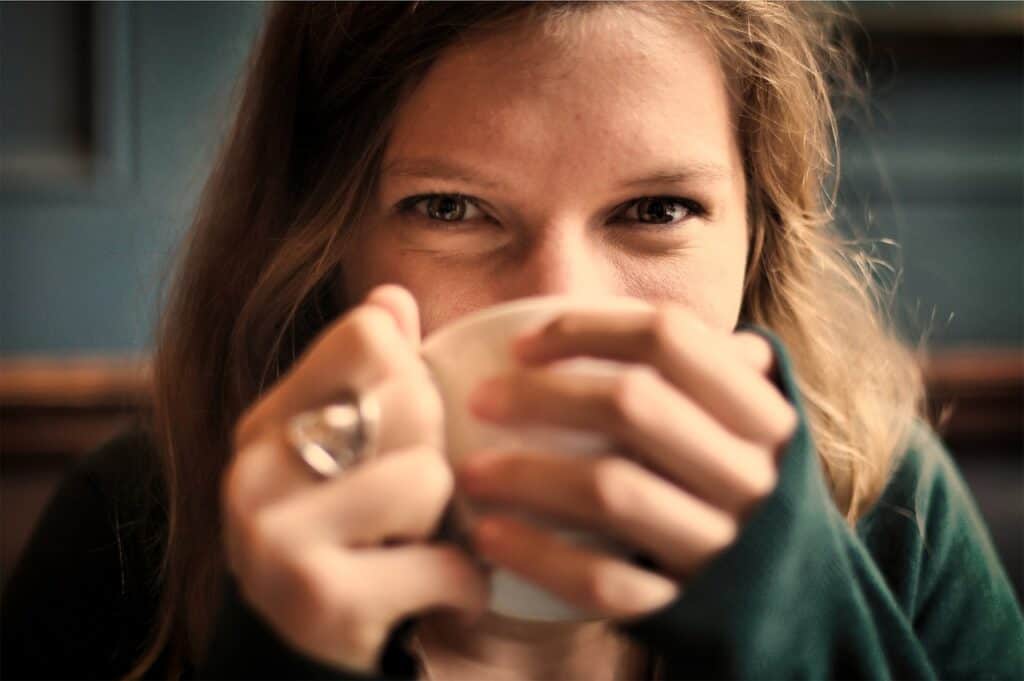 Person holding a warm drink in a restful home environment