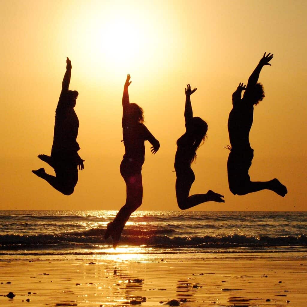 People jumping on the beach representing healthy home living and wellbeing