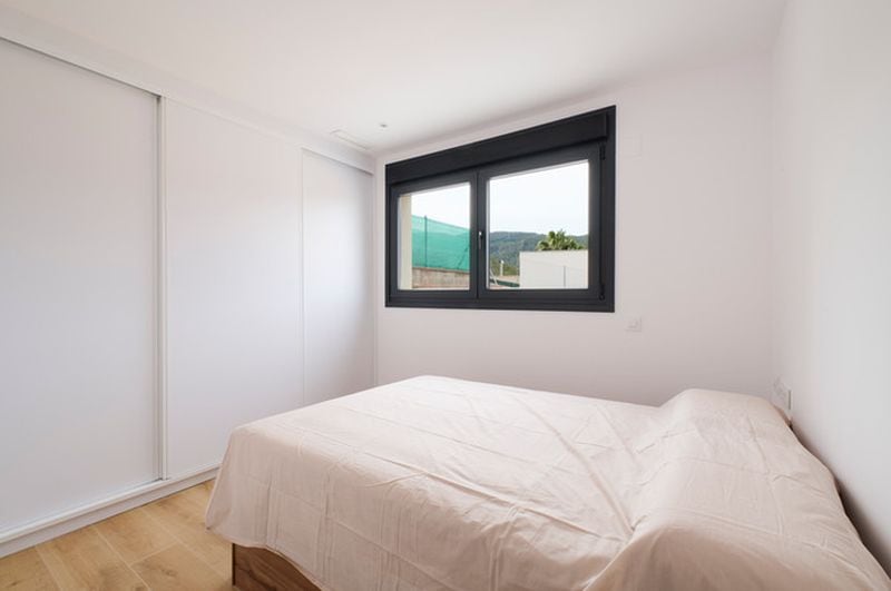Habitación minimalista con cama y ventana grande