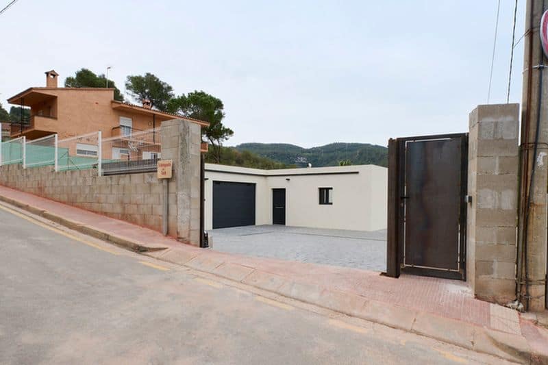 Entrada de casa moderna en calle inclinada.