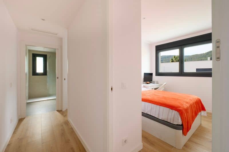 Pasillo al dormitorio con cama naranja moderna