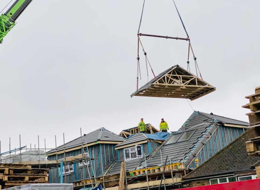 Roof construction by Moduloft with crane lifting roof sections.