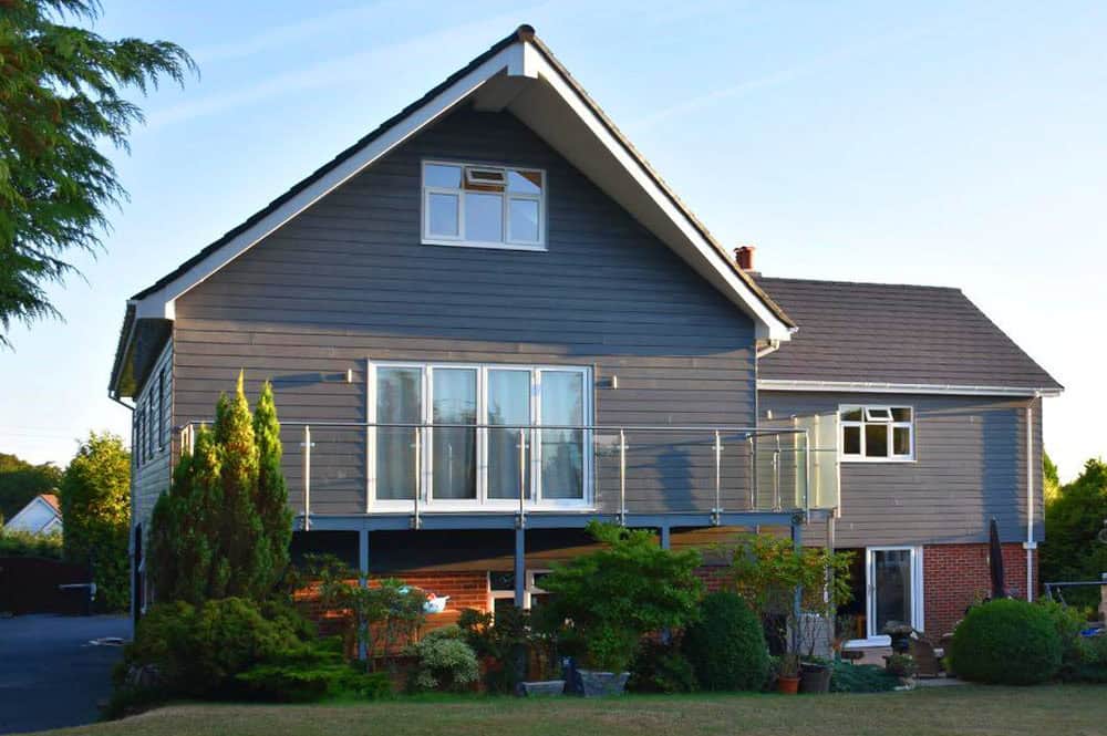 Modern two-storey house with grey cladding and balcony in Axminster, Devon.