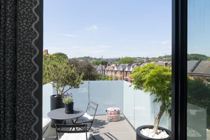 Balcony with potted plants and cityscape view from Moduloft.