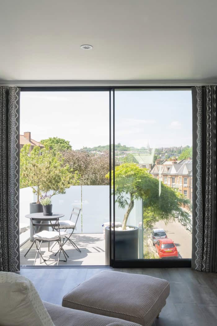 Bright living room with large glass sliding doors to balcony and cityscape view.