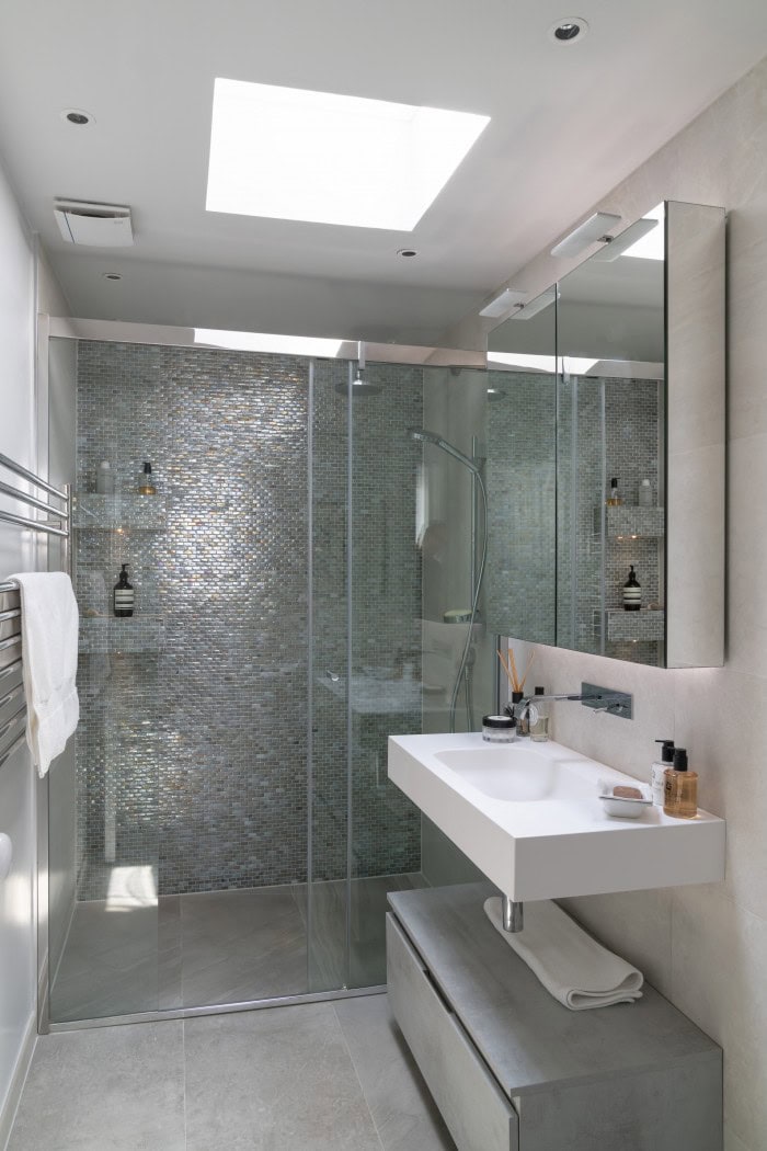 Contemporary bathroom with glass shower, white sink, and sleek design.