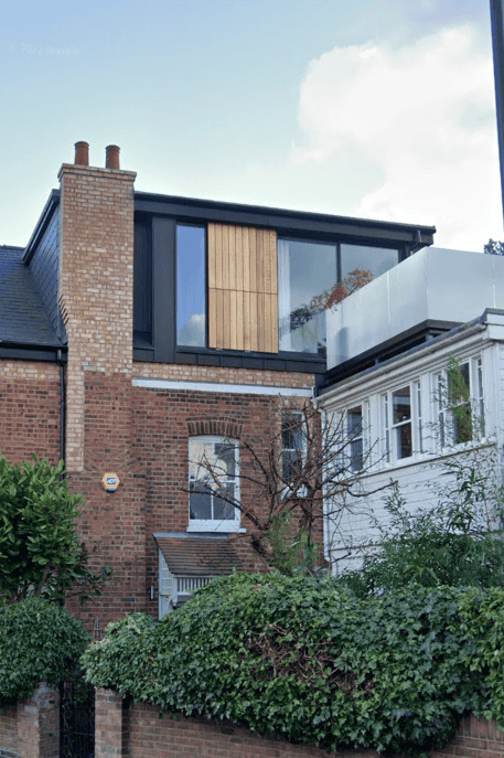 Modern extension with large glass windows on a brick building.