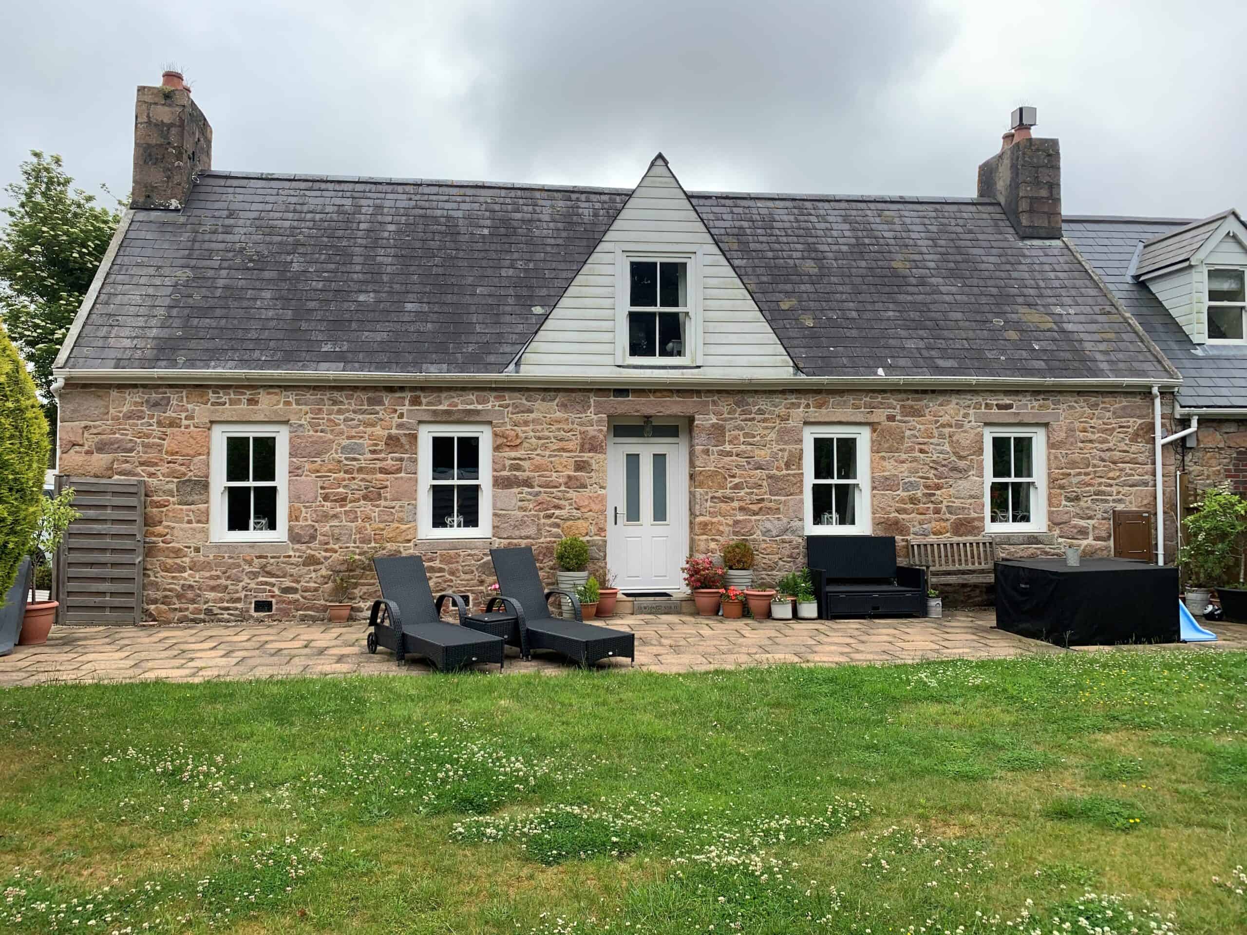 Traditional stone cottage with outdoor seating and garden area in UK.