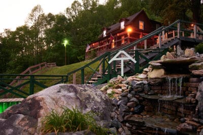 Secluded mountain harbor house with waterfalls and lush forest scenery in the mountains.