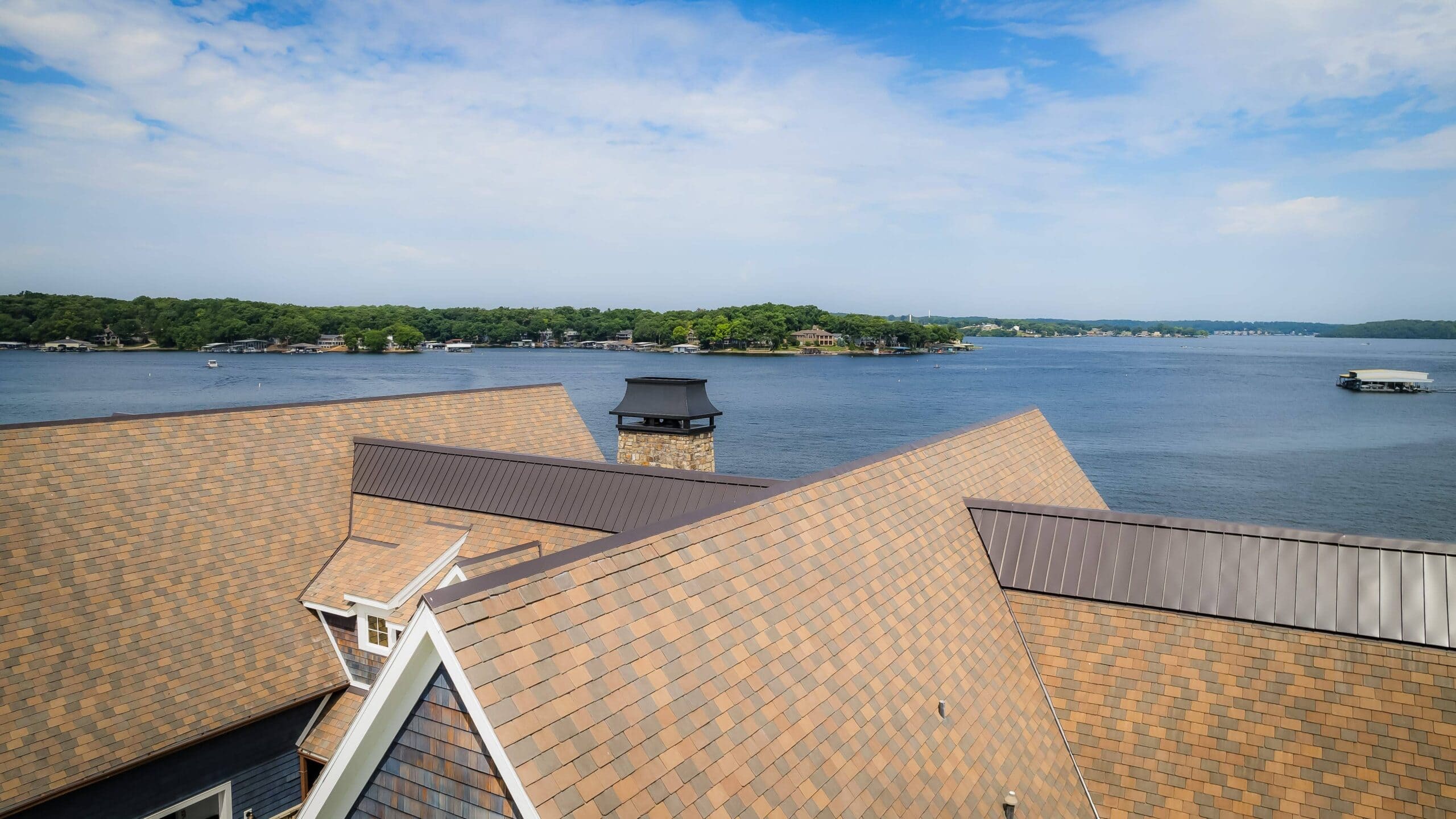 Beautiful lakeside view with new residential roofing, showcasing quality craftsmanship by Midwest Roofing.