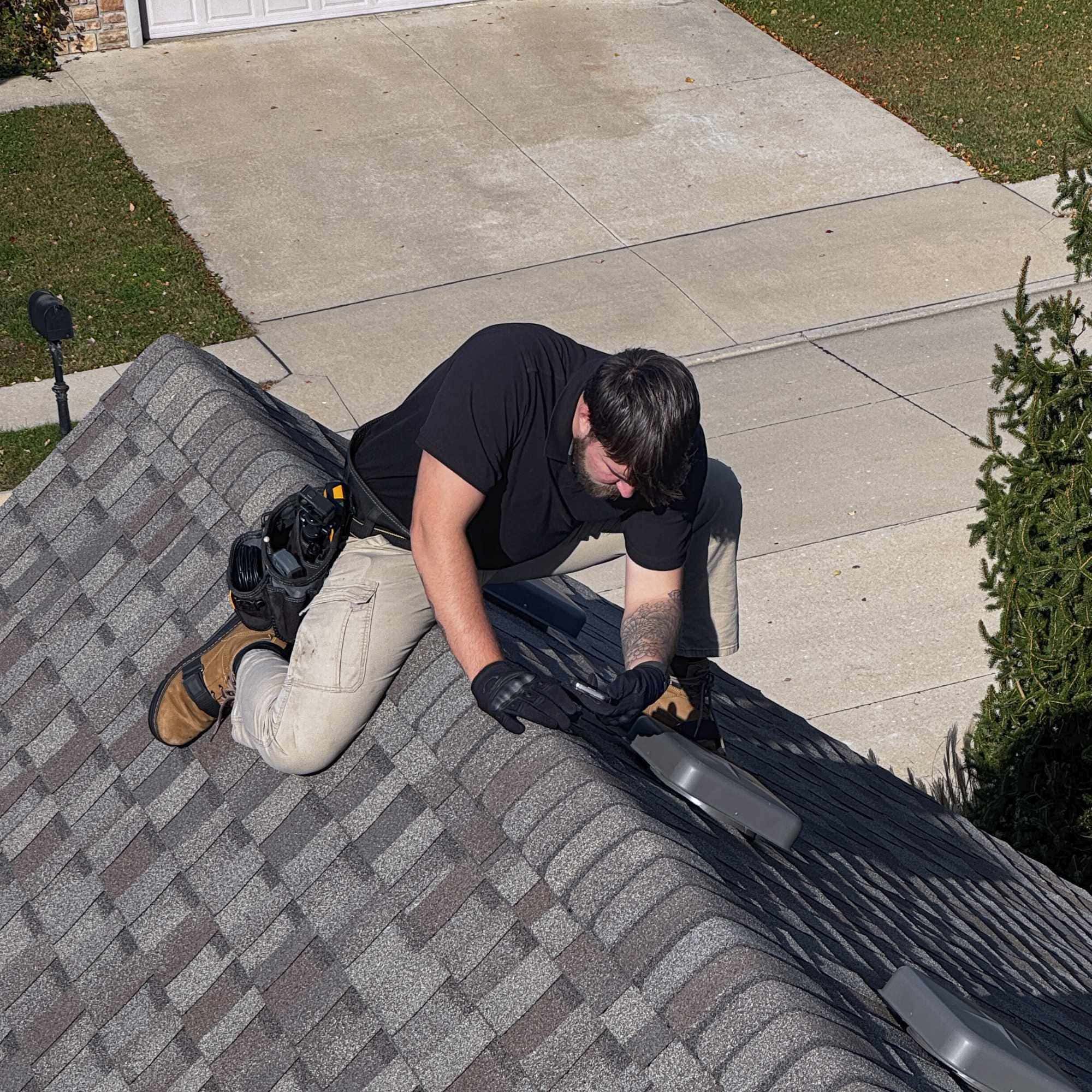 Experienced roofer inspecting shingles on house roof for leaks and damage. Expert roofing solutions by Midwest Roofing.