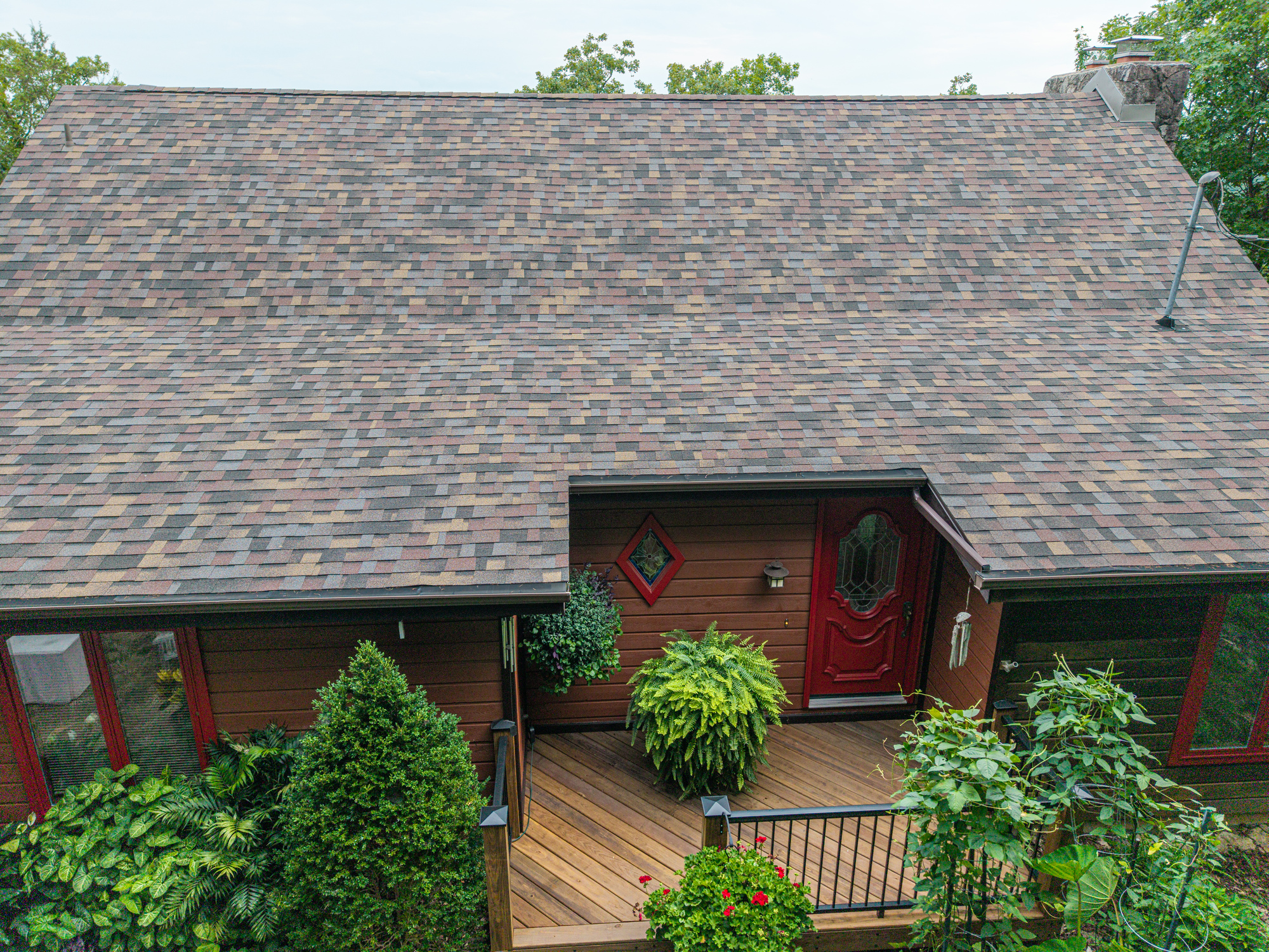 Residential roof with new shingles and a well-maintained yard in Camdenton, MO.