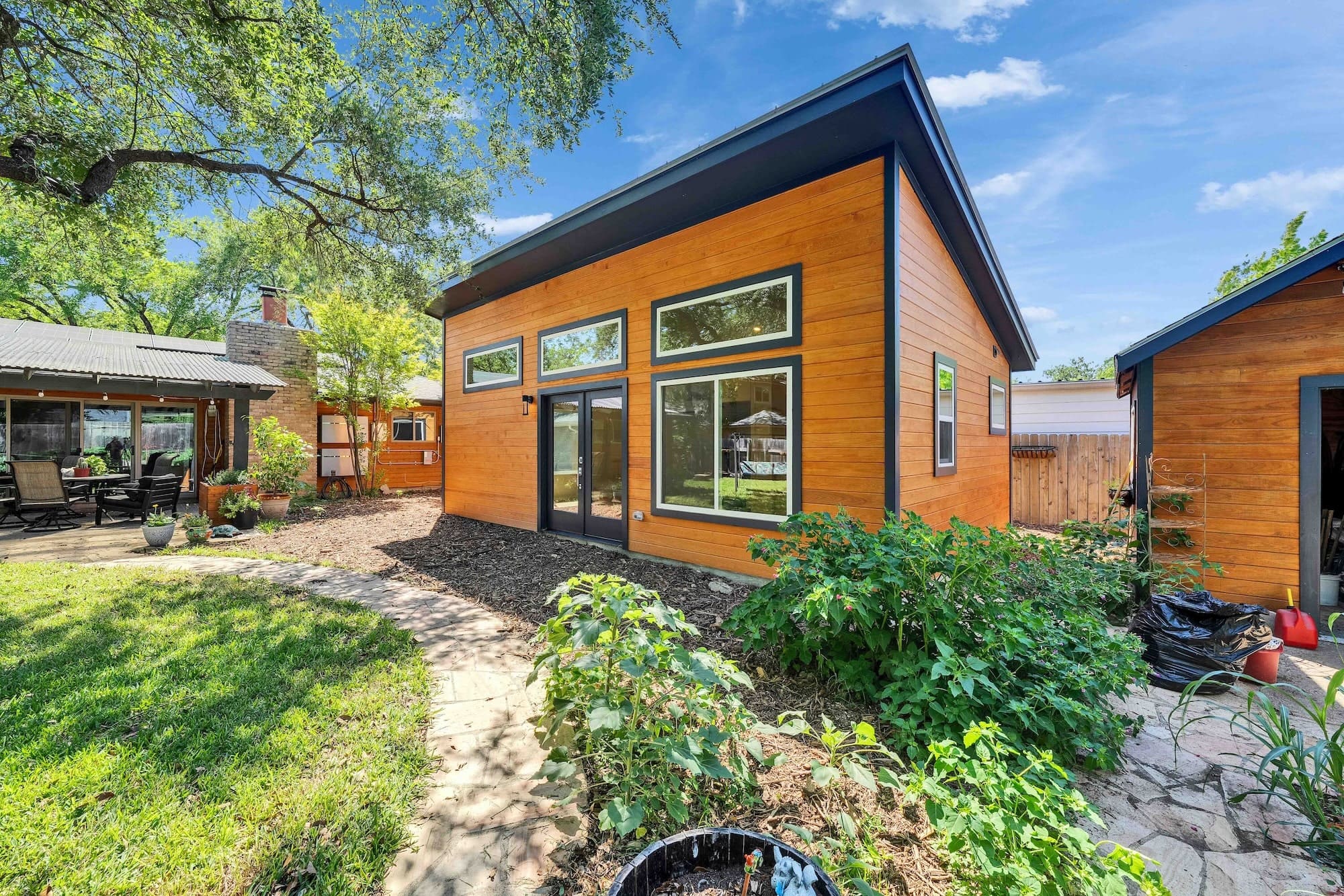 Modern wooden backyard studio with garden pathway