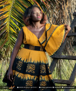 Robe batik couleur or et noire, évasée à double ovale superposées, manches asymétriques à volants, avec ceinture brodée.