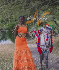 Robe longue brodée, en pagne tissé orange à brillantine or, Avec ceinture large brodée. Foulard et chapeau brodé assortis.