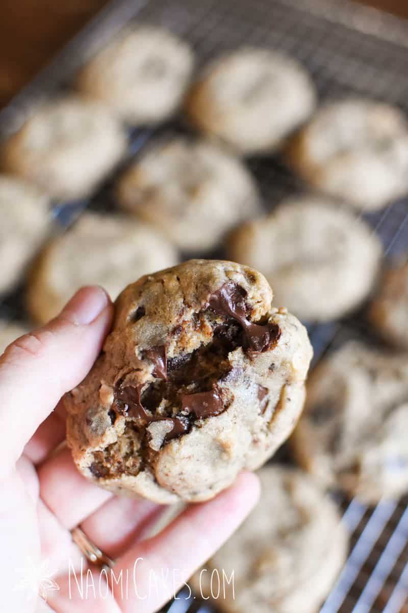 a hand breaking open a chocolate fudge cookie