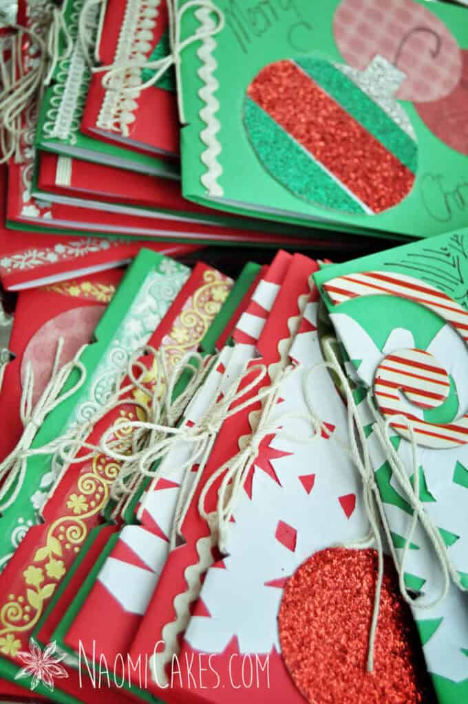 a close up photo of homemade Christmas cards with string binding and paper cutouts