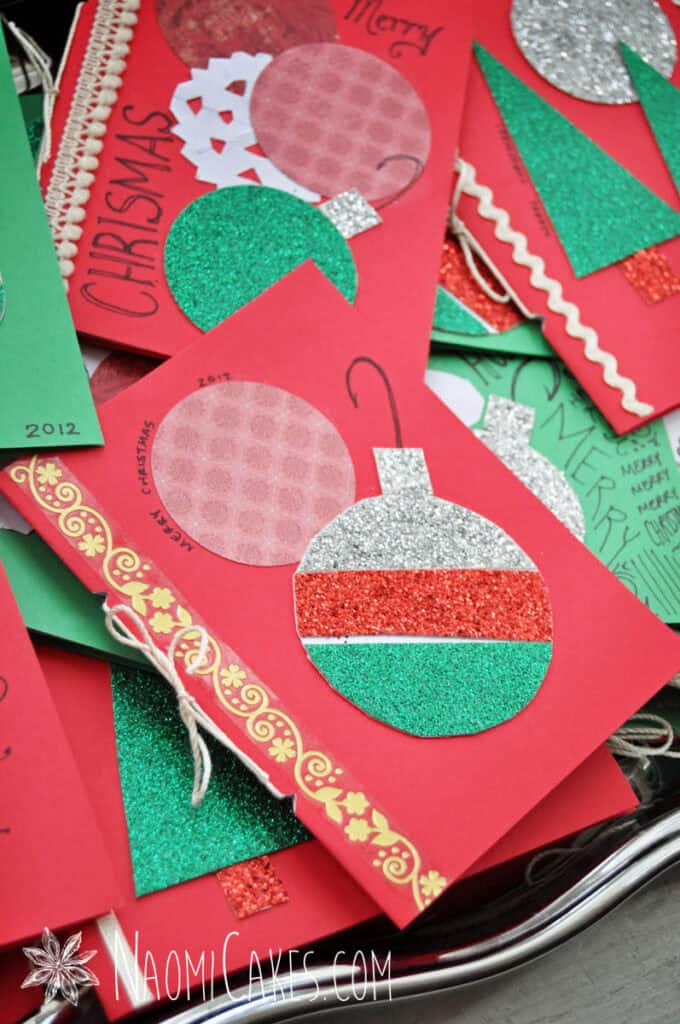 a pile of homemade red and green Christmas cards on a silver tray