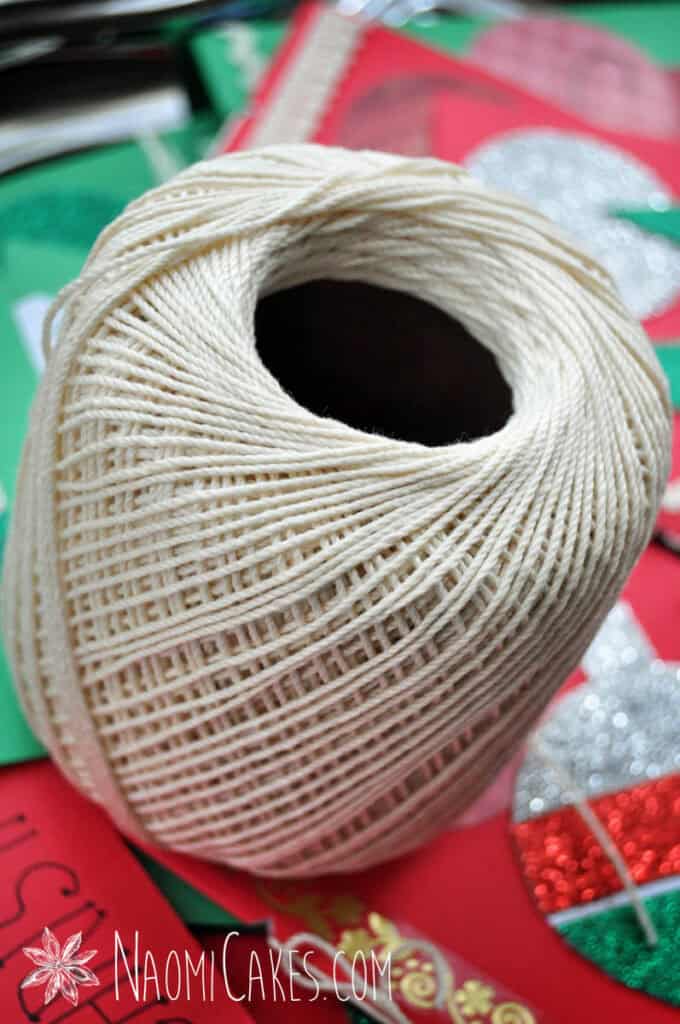 a spool of cotton string with red and green in the background