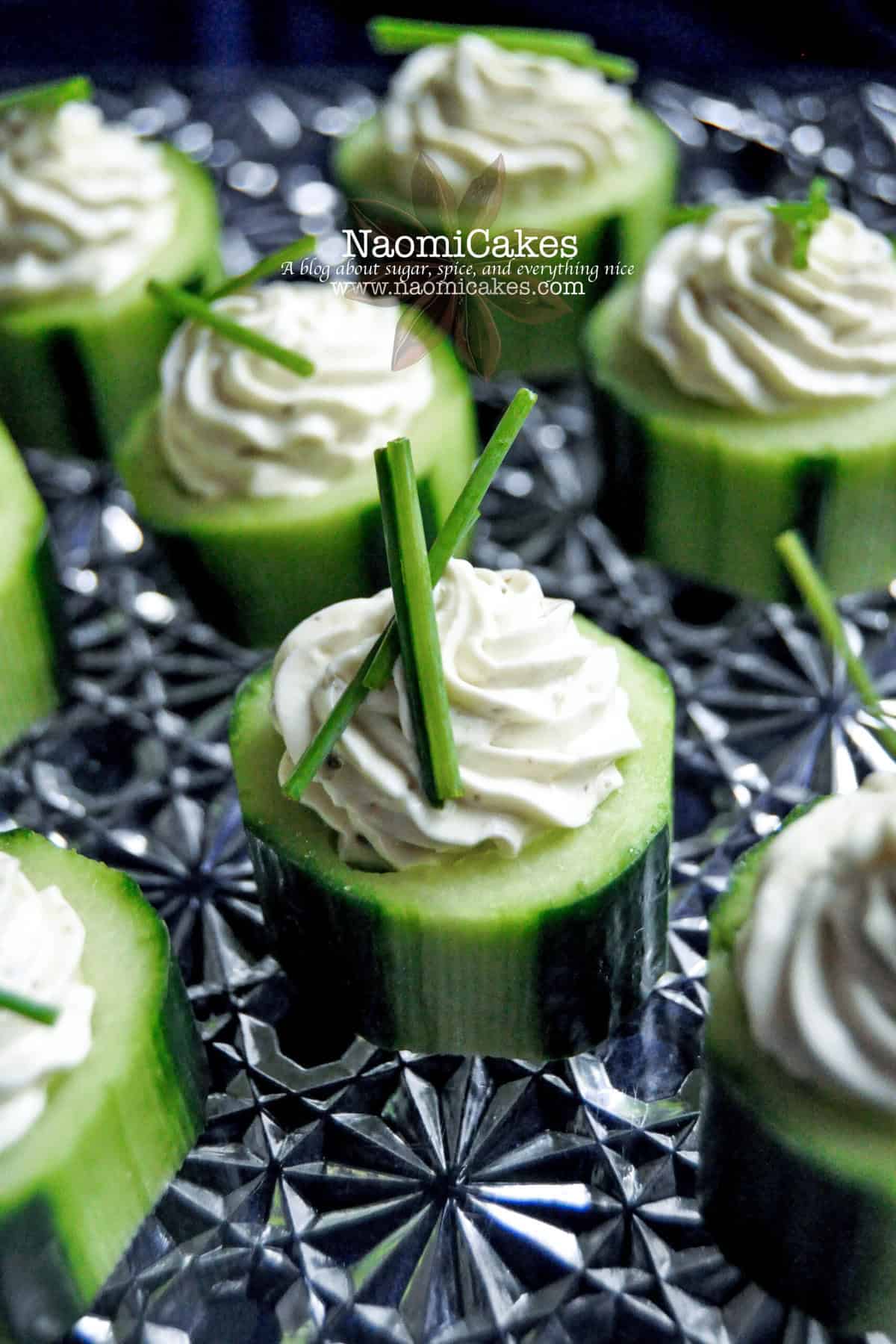 cucumber appetizer with a creamy swirl of filling in the middle and chives on top