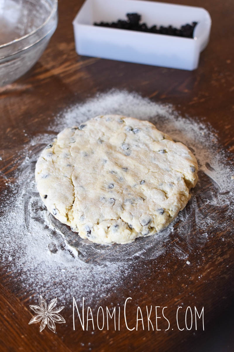 8" circle of scone dough on a wooden table with flour