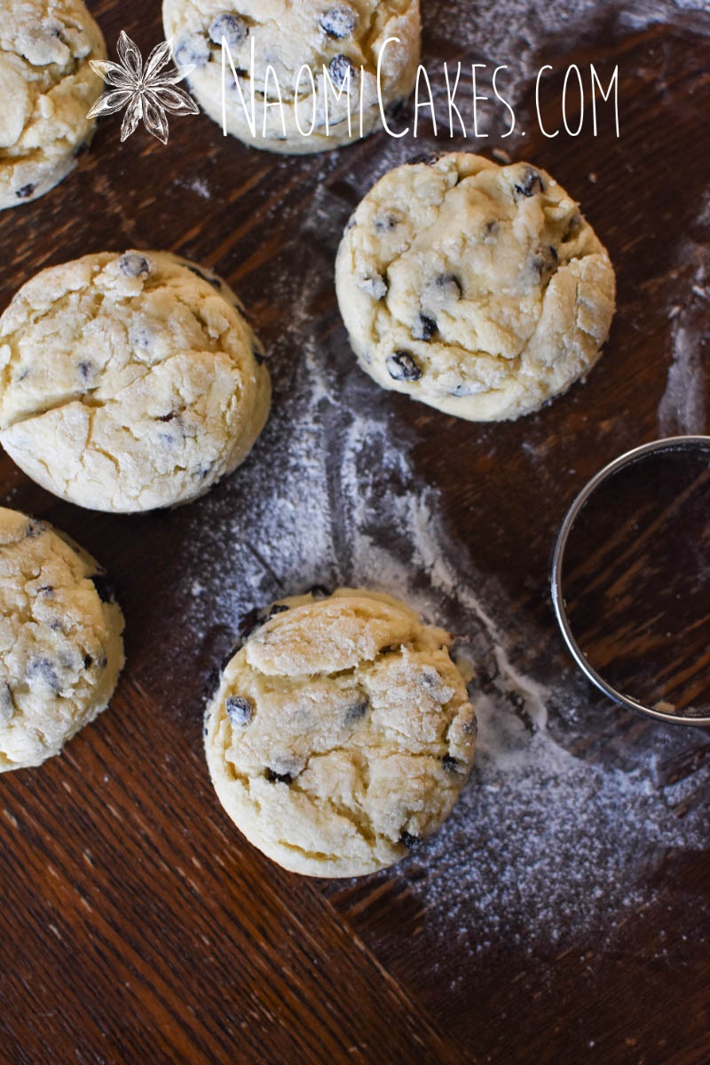 6 cut out currant scones with a biscuit cutter on a wooden table
