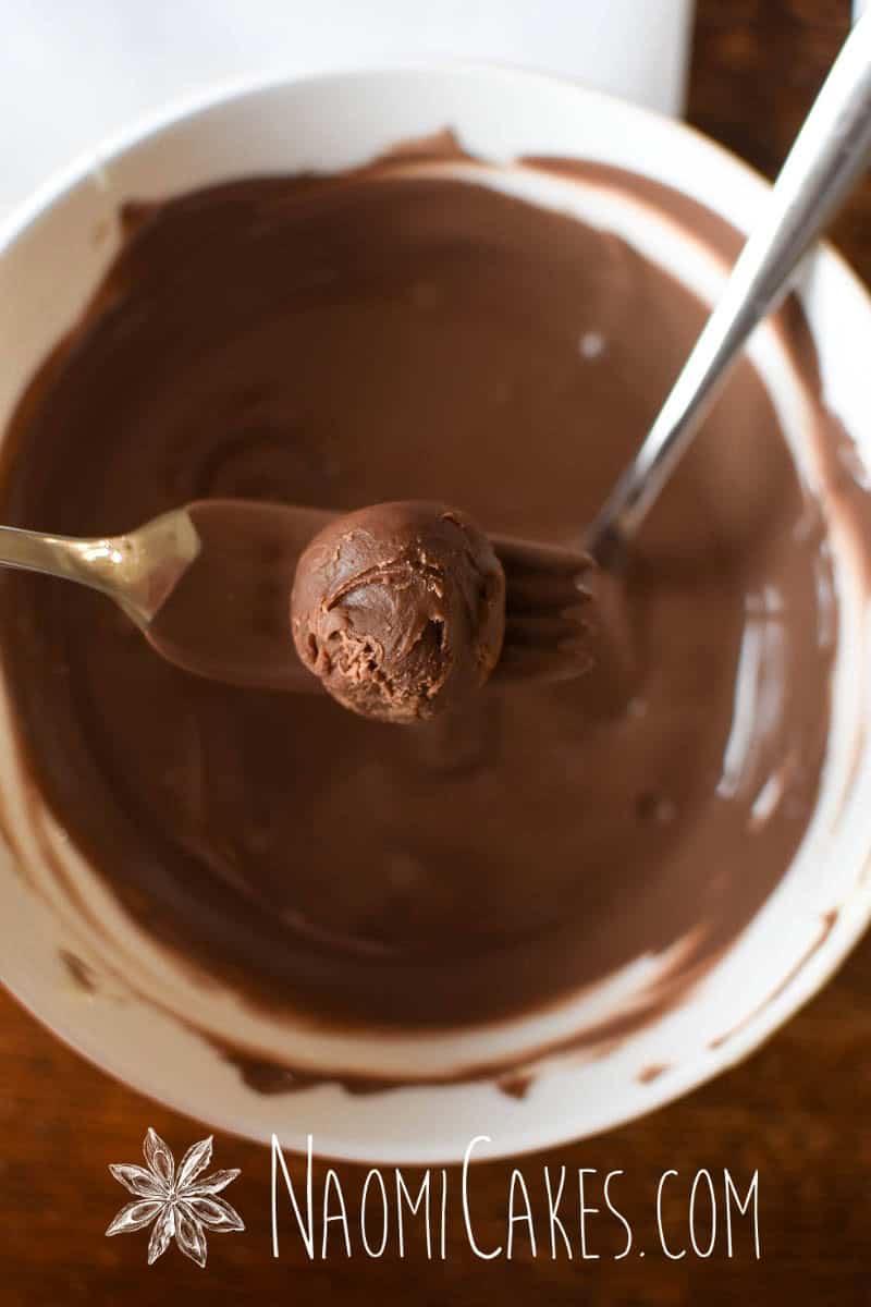a truffle about to be dipped in melted milk chocolate